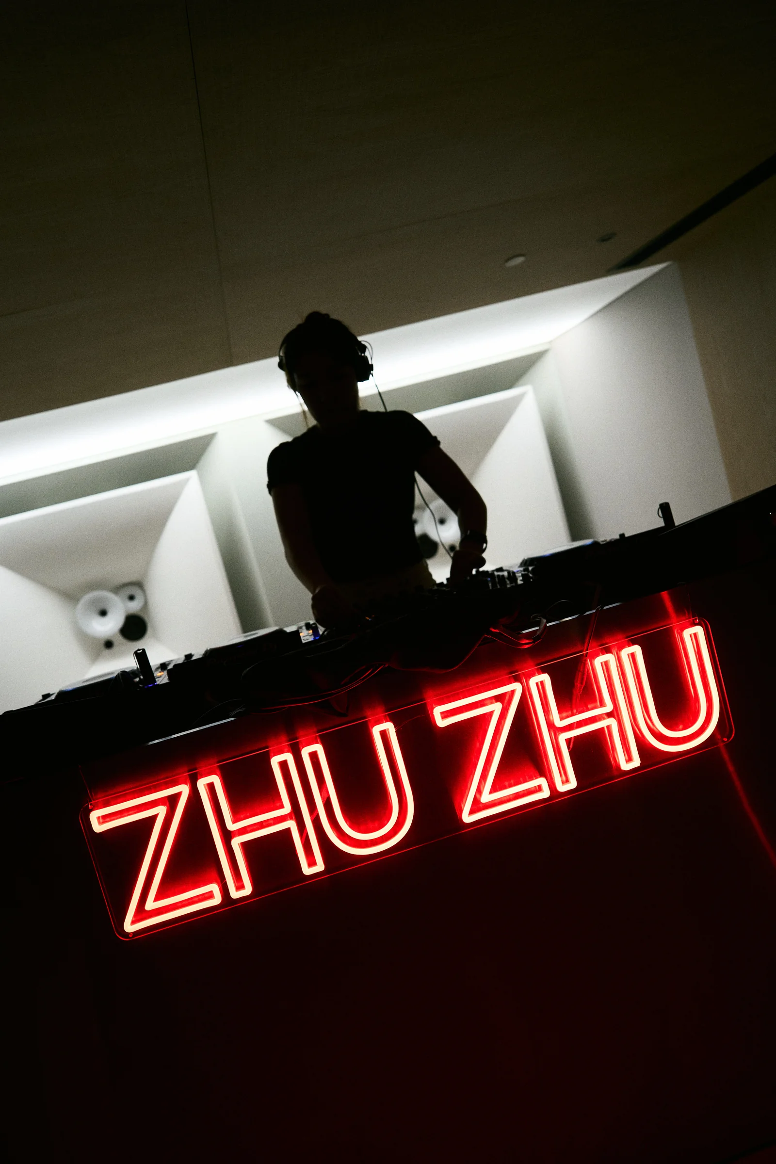 ZHU ZHU neon-red event sign with DJ silhouette.
